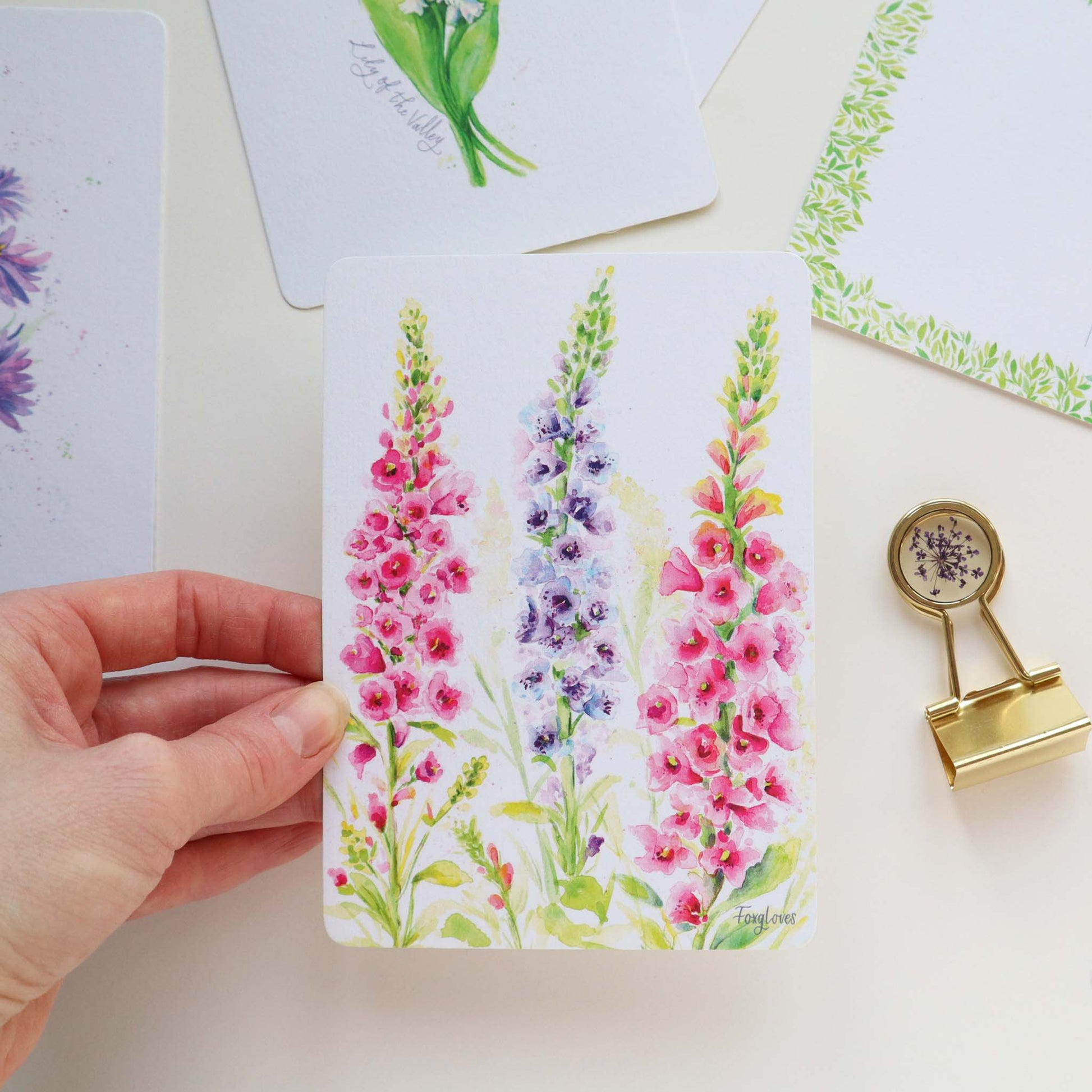 Hand holding a Postcard with a Foxglove design 