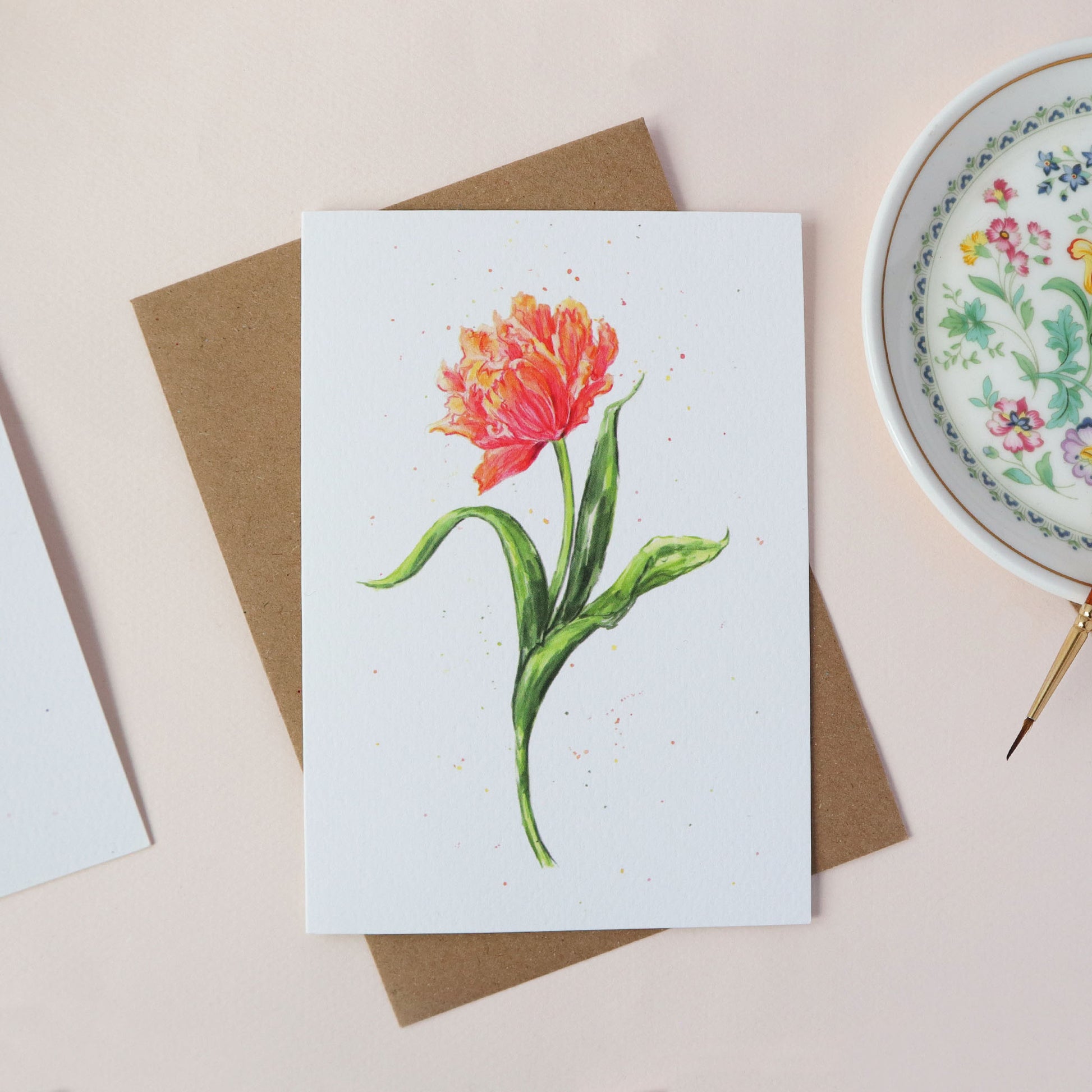 Card with a red and orange tulip illustration on a white surface