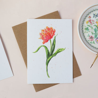 Card with a red and orange tulip illustration on a white surface