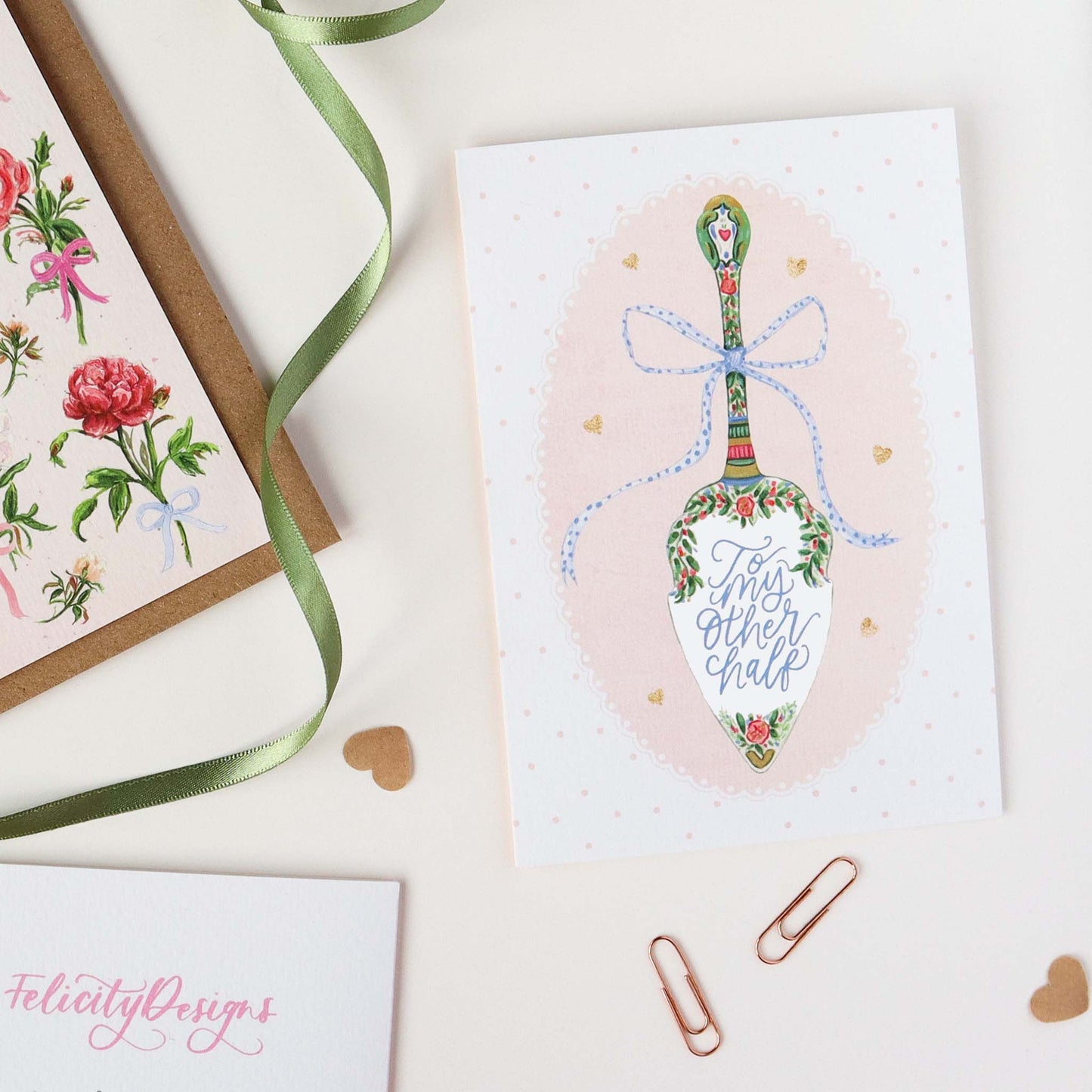 Greeting card with decorative cake slice design and ribbon on a white surface